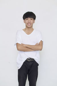 Portrait of smiling man standing against white background