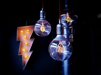 Close-up of illuminated lamp over black background