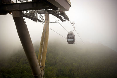 Amazing cable car lines and carriages over jungle in thick fog