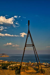 Metallic structure by sea against sky