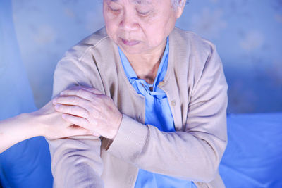 Cropped hand consoling senior patient at hospital