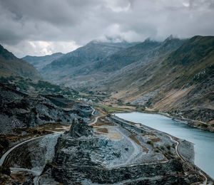 Aerial view of road by mountains against sky