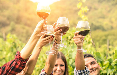 Midsection of friends drinking glass