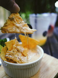 Close-up of hand holding ice cream in bowl