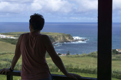 Rear view of woman looking at sea against sky