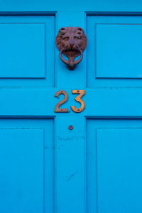 House number 23 on a blue wooden front door in london 