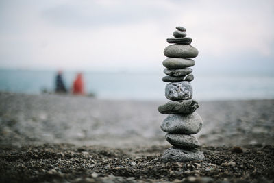 Stack of pebbles on beach against sky