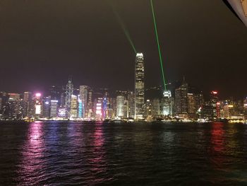 Illuminated buildings in city against sky at night