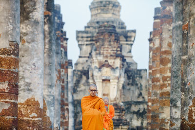 Monks wearing traditional clothing standing in row at temple