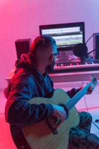 Side view of a man playing guitar