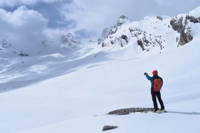 Man on snowcapped mountain against sky