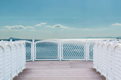 Sea seen through railing against sky