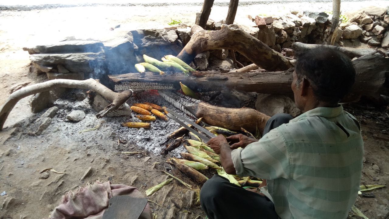 REAR VIEW OF PEOPLE RELAXING ON WOODEN LOG