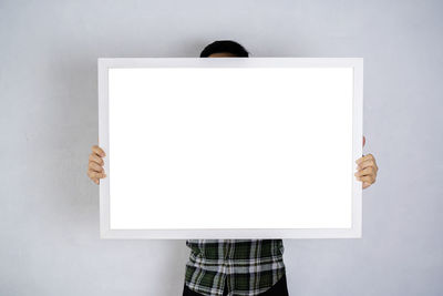 Low angle view of woman holding umbrella against white background