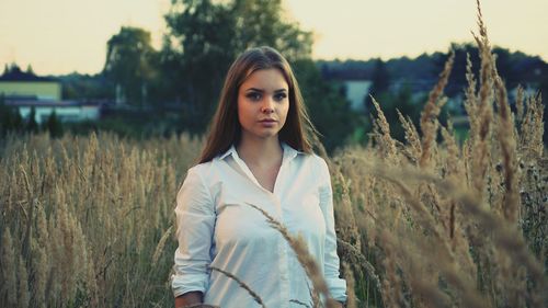 Portrait of young woman standing in field