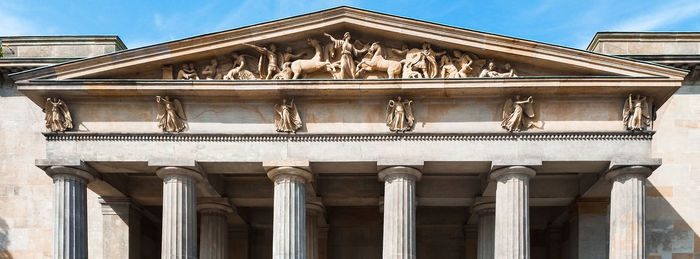 Low angle view of statues on building against sky