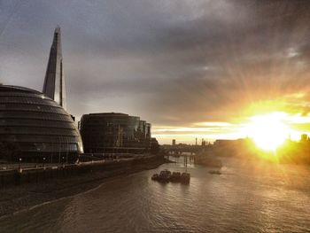 Sun shining through clouds over city