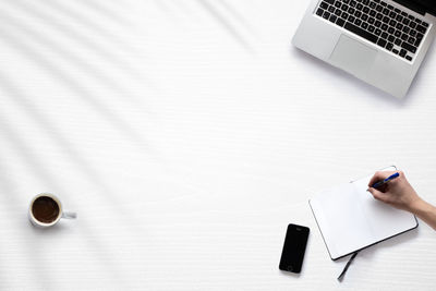 Cropped hands of woman using laptop on table
