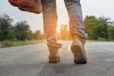 Low section of surveyor walking on road