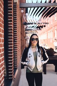 Portrait of woman in sunglasses standing on footpath