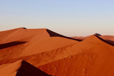 Sand dunes in desert against clear sky