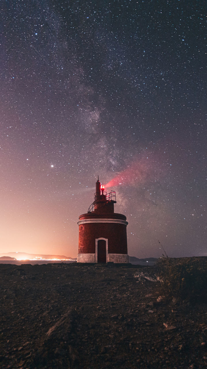 lighthouse, star, night, sky, astronomy, space, architecture, galaxy, scenics - nature, nature, tower, built structure, beauty in nature, building exterior, astronomical object, milky way, building, landscape, environment, science, land, red, no people, space and astronomy, guidance, travel destinations, outer space, star field, darkness, outdoors, constellation, tranquility