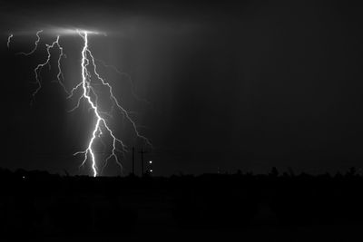 Lightning over land against sky at night