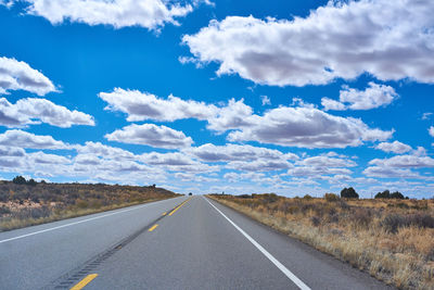Empty road against cloudy sky