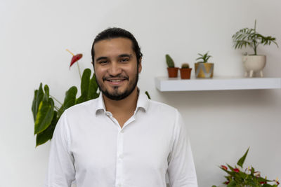 Portrait of young man standing against wall