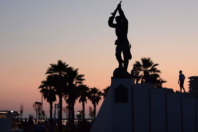 Silhouette statue against clear sky during sunset