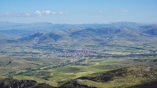 Aerial view of agricultural field and mountains against sky