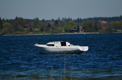 Boat sailing on sea against clear sky