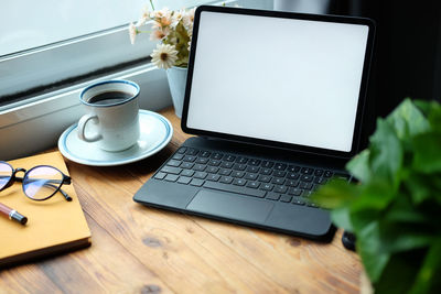 High angle view of coffee and laptop on table