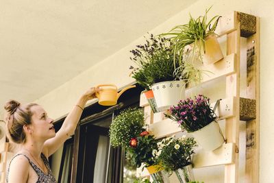 Woman standing by potted plant