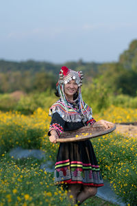 Woman with umbrella standing on field