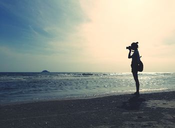 Woman photographing at beach