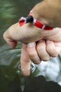 Close-up of hand touching water in lake