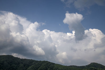 Low angle view of clouds over mountain against sky