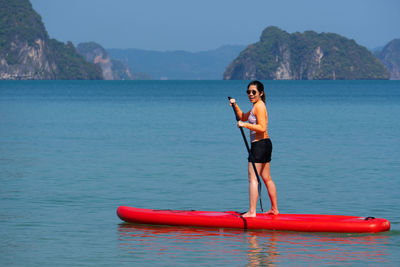 Full length of senior man in sea against mountains