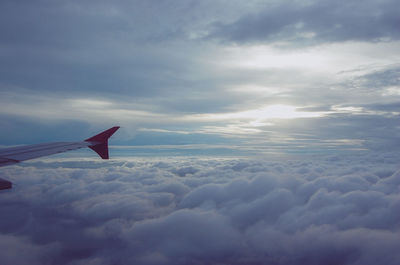 Airplane flying over cloudscape against sky