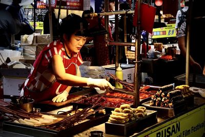 Woman at market stall for sale