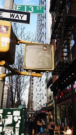 Low angle view of road sign against sky in city