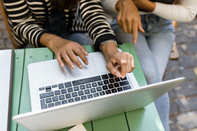 Businesswomen using laptop while discussing in cafe