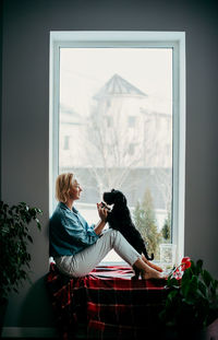 Side view of dog sitting on window