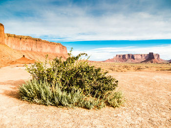 Scenic view of rock formations on landscape against cloudy sky