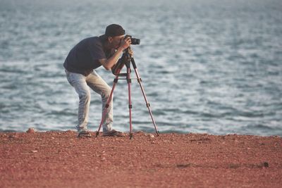 Side view of man photographing at beach