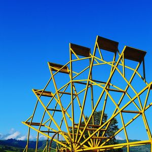 Low angle view of ferries wheel against clear blue sky
