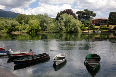 Boats moored in lake against sky