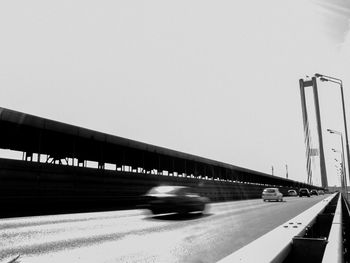 Blurred motion of train on road against clear sky