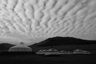 Boats in sea against cloudy sky